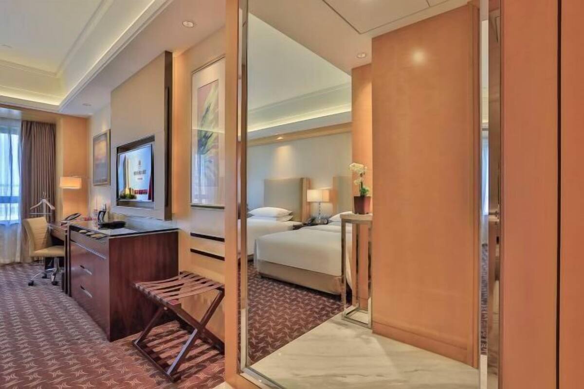 Une chambre d’hôtel équipée d’un bureau, d’une chaise, d’un lit et d’un petit coin salon.