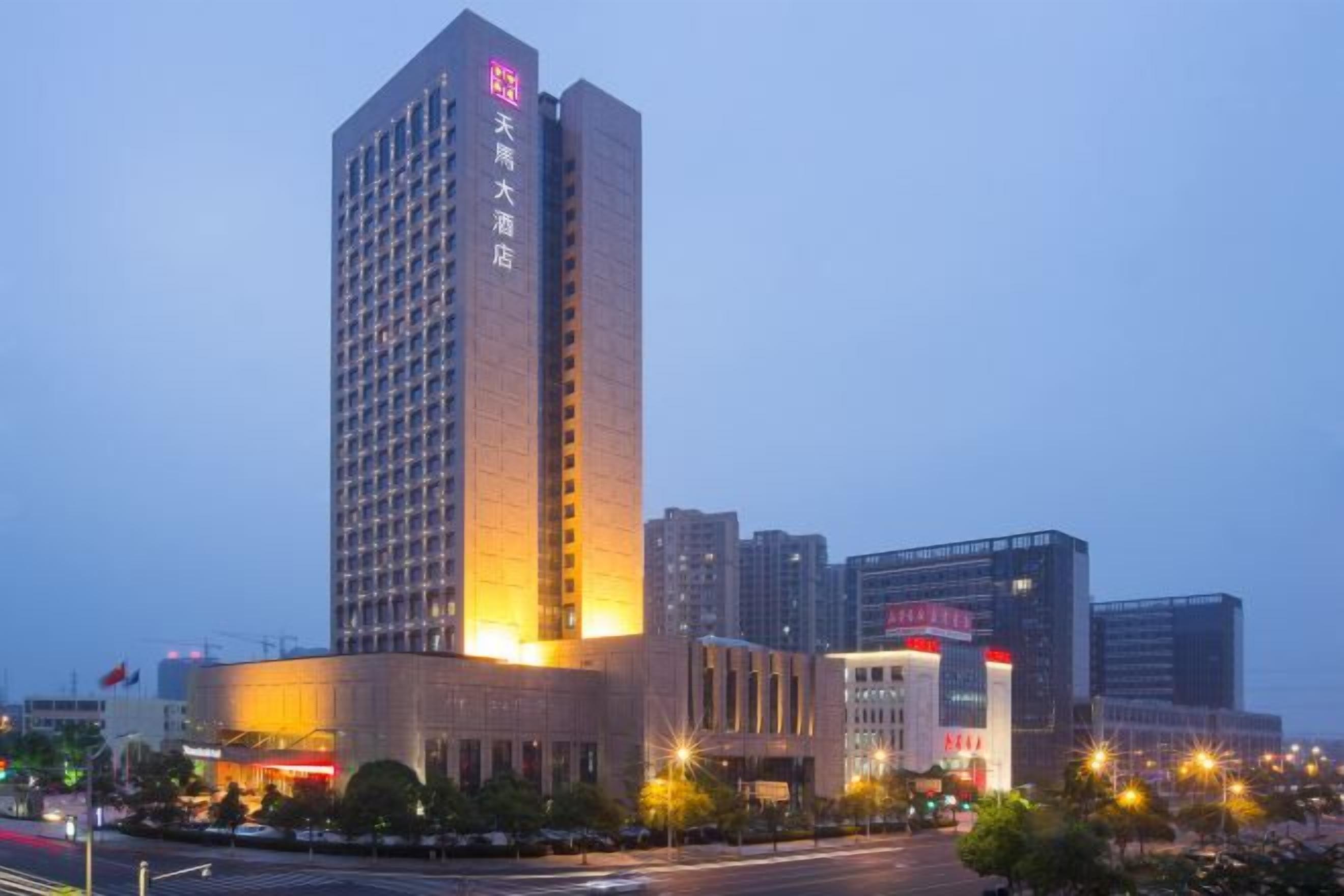 Un hotel de gran altura con una entrada destacada y un letrero grande.