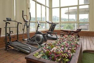 Un gimnasio con equipo de ejercicio y un parterre floral.