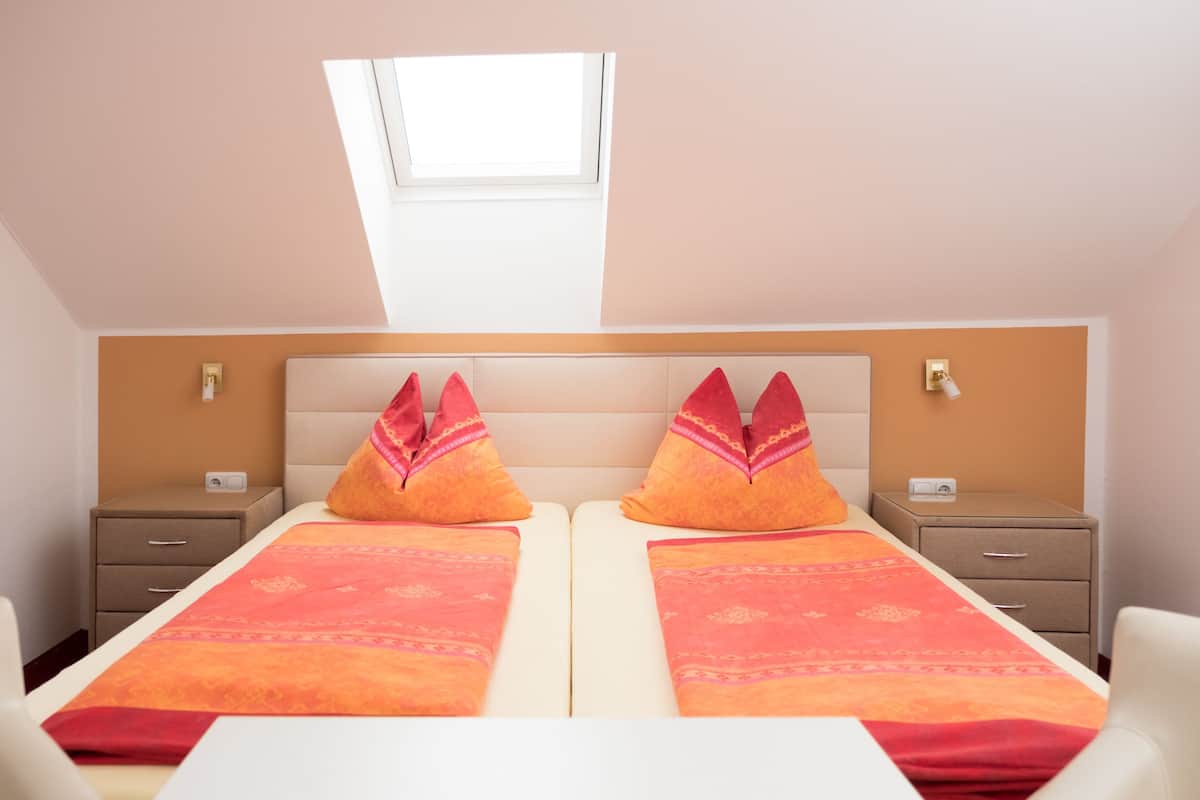 Un dormitorio con dos camas, un tragaluz y vistas al cielo.