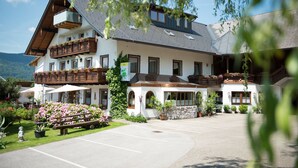 Ein großes, zweistöckiges Gebäude mit Balkon, Außenbereich und Parkplatz.