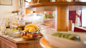 Ein Buffetbereich mit verschiedenen Speisen, darunter Obst und Gerichte in einer Glasvitrine.