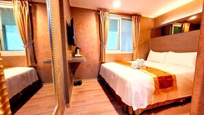 Una habitación de hotel con cama, televisión, una mesita con cafetera y un espejo.