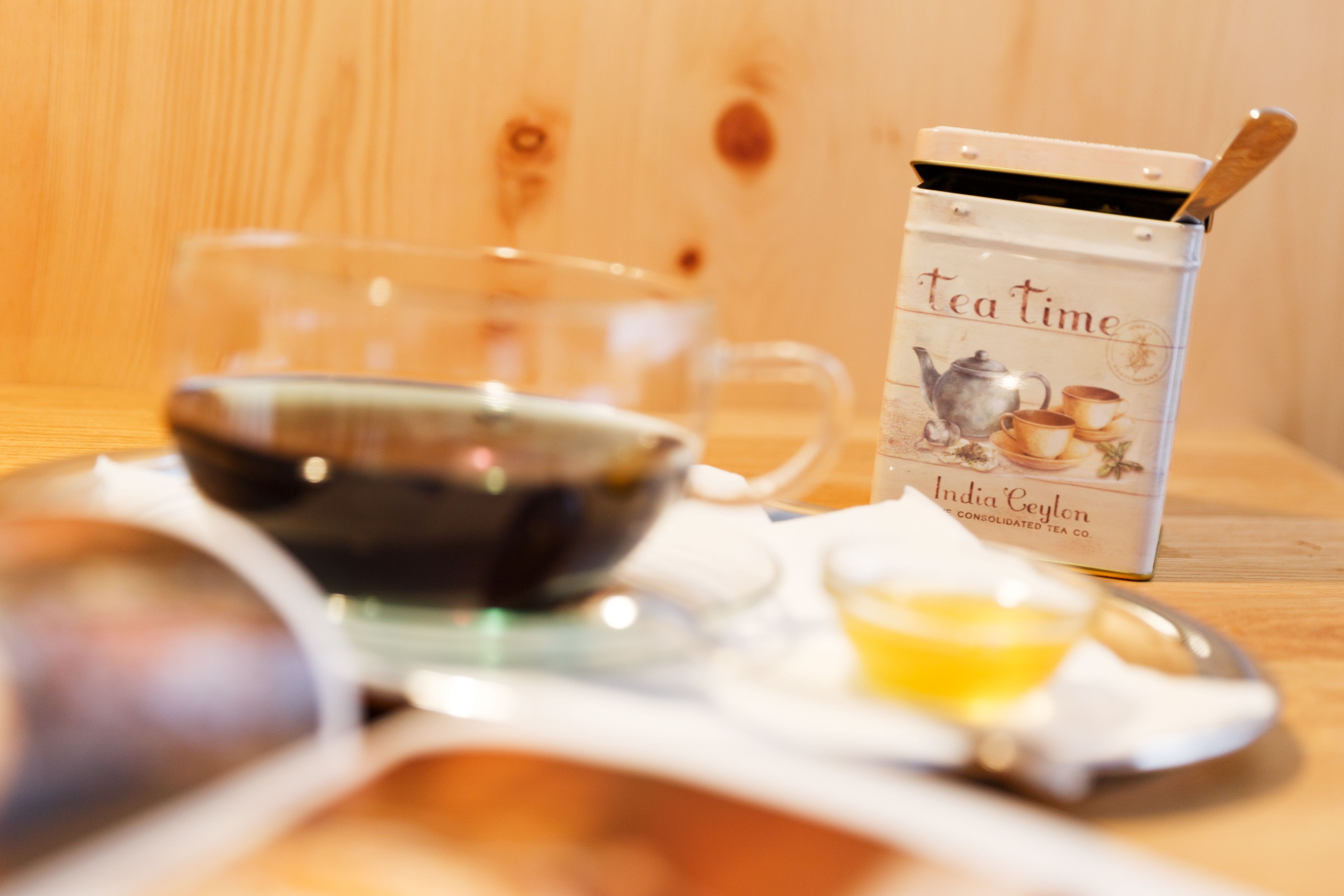 Un service à thé comprenant une théière, des tasses et un plateau, le tout posé sur une table en bois.