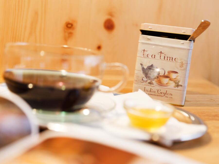 Un service à thé comprenant une théière, des tasses et un plateau, le tout posé sur une table en bois.
