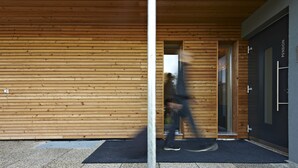 A modern building with wooden paneling and a glass door labeled "PENSION." - Pension Jageredt (Nussbach)
