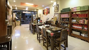 A restaurant interior with wooden furniture, a tiled floor, and shelves stocked with condiments and beverages. - LakeView Homestay (Yuchi)