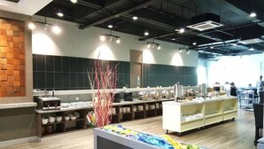 Un restaurante moderno con una barra larga, varias zonas de estar y una planta decorativa.