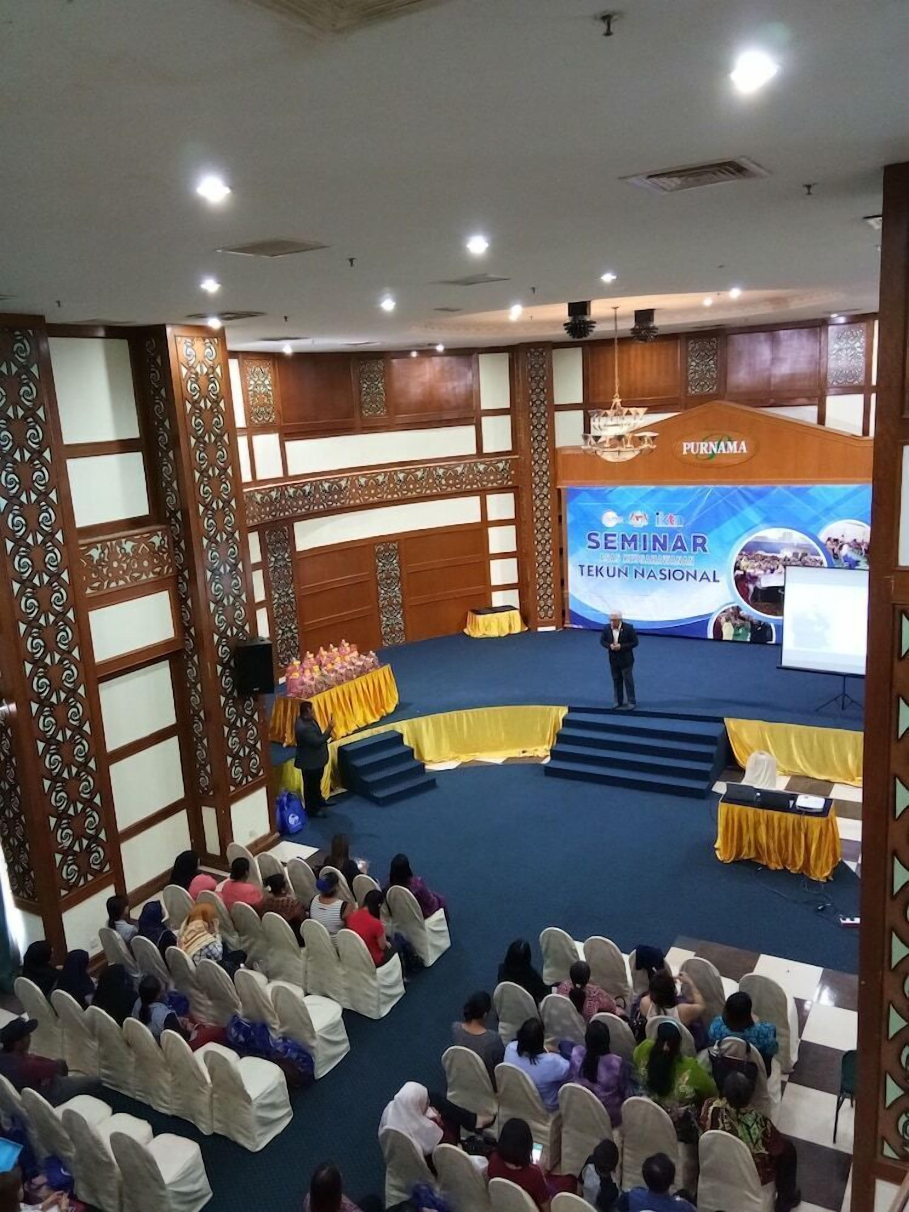 A seminar room with a stage, audience seating, and a podium.