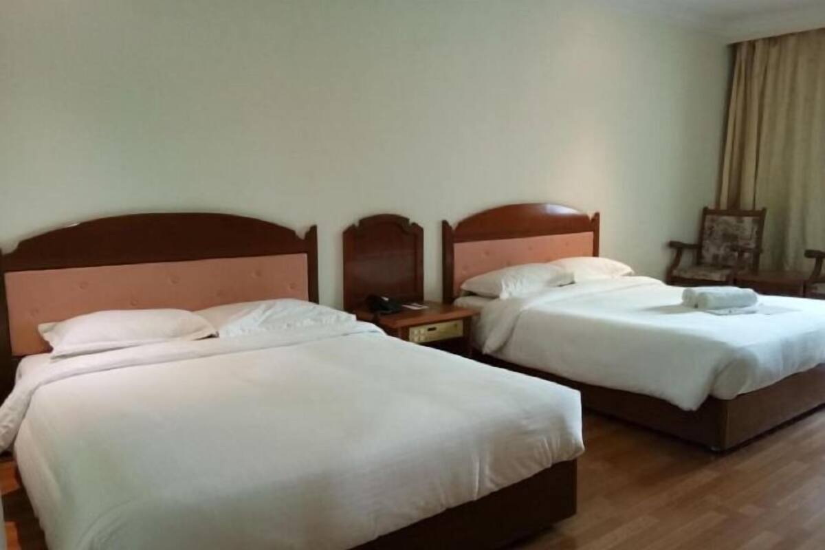 Dos camas individuales con cabeceros de madera en una habitación de hotel.