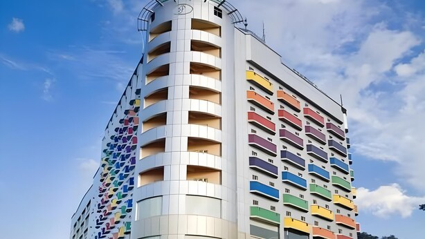 Un edificio de varios pisos con una fachada distintiva que combina balcones y ventanas.