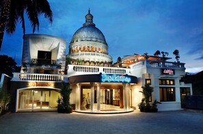 A hotel with a prominent dome structure, a sign for 'The Palais Hotel', and a 'Nanomix' store. - The Palais Dago Hotel (Bandung)