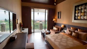 Une chambre d’hôtel avec un grand lit, un bureau, un canapé et un balcon avec vue.