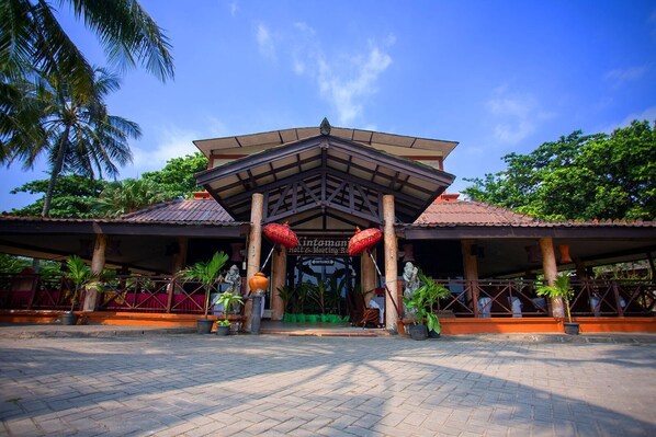 A traditional building with a tiled roof, a central entrance, and a covered walkway. - Nuansa Bali (ANYER)