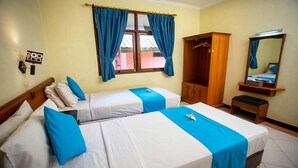 Une chambre d’hôtel avec deux lits, une armoire, un miroir et une fenêtre avec des rideaux.
