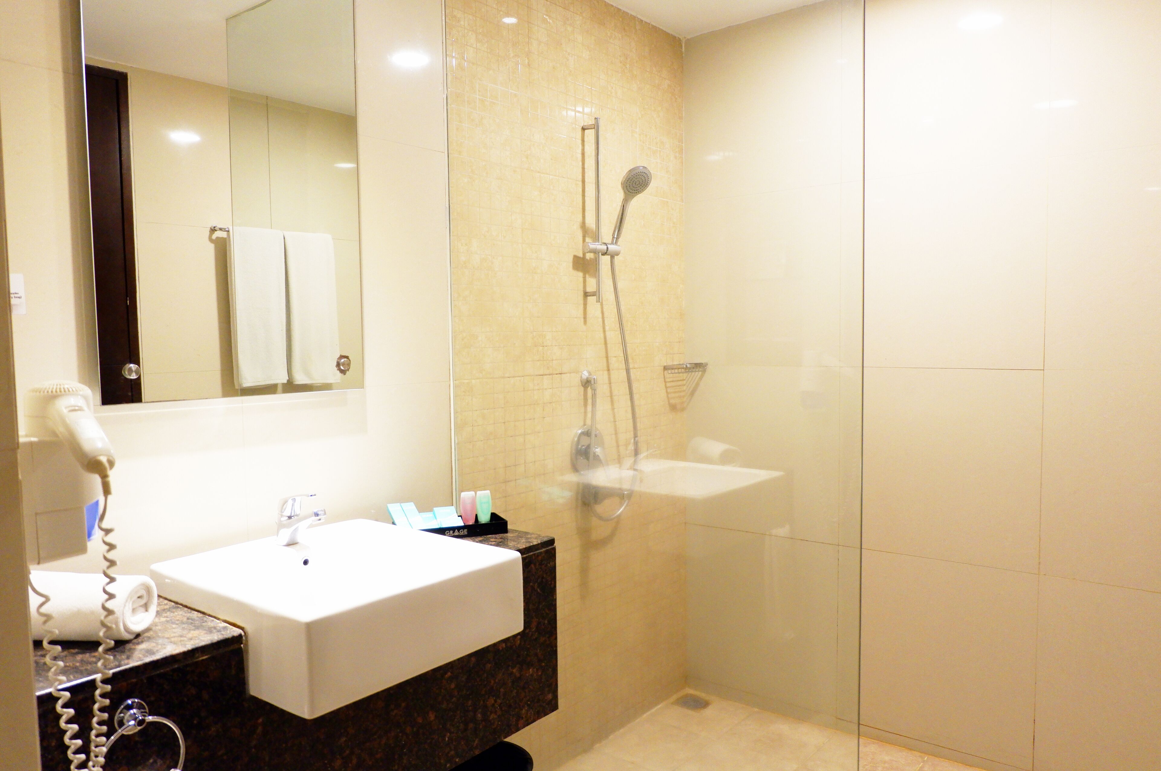 Un baño con lavabo, espejo y ducha.