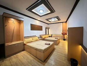 A bedroom with a bed, a wardrobe, a bedside table, and a ceiling light fixture. - Satria Cirebon (Cirebon)
