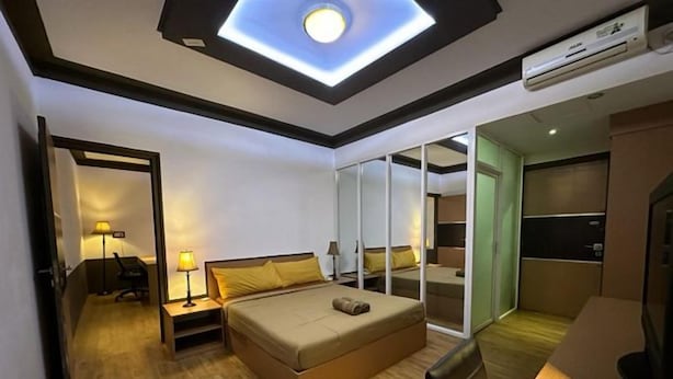 A hotel room with a bed, bedside tables, a desk, and a ceiling light. - Satria Cirebon (Cirebon)