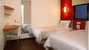 Une chambre d’hôtel avec deux lits, un bureau avec une chaise, un téléphone et une fenêtre donnant sur un beau paysage.