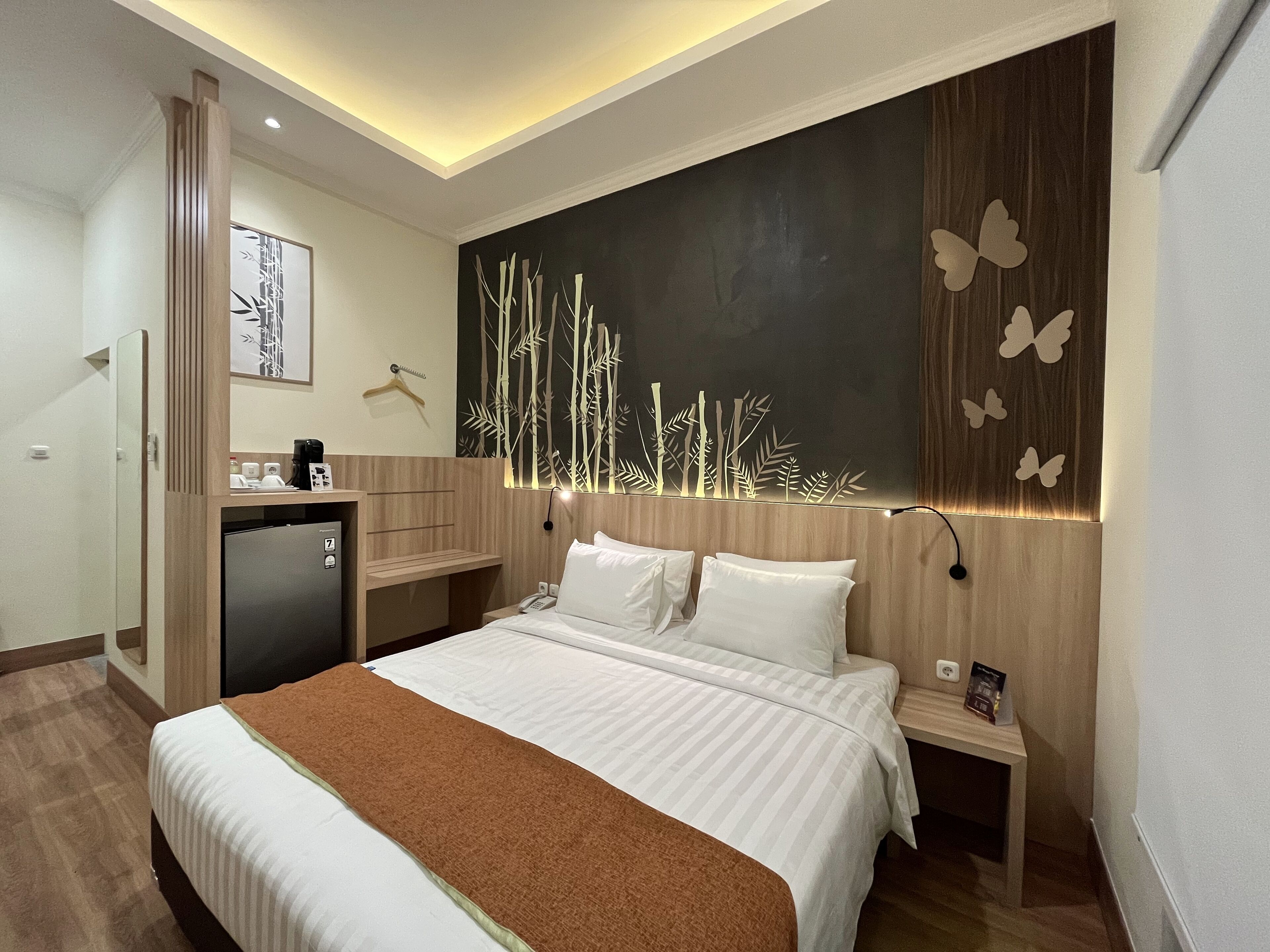 Una habitación de hotel moderna con una cama grande, un escritorio y un armario.