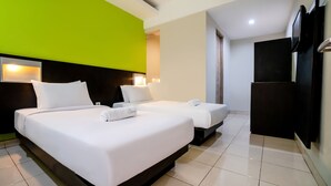 Habitación de hotel con dos camas, televisión y un minibar.