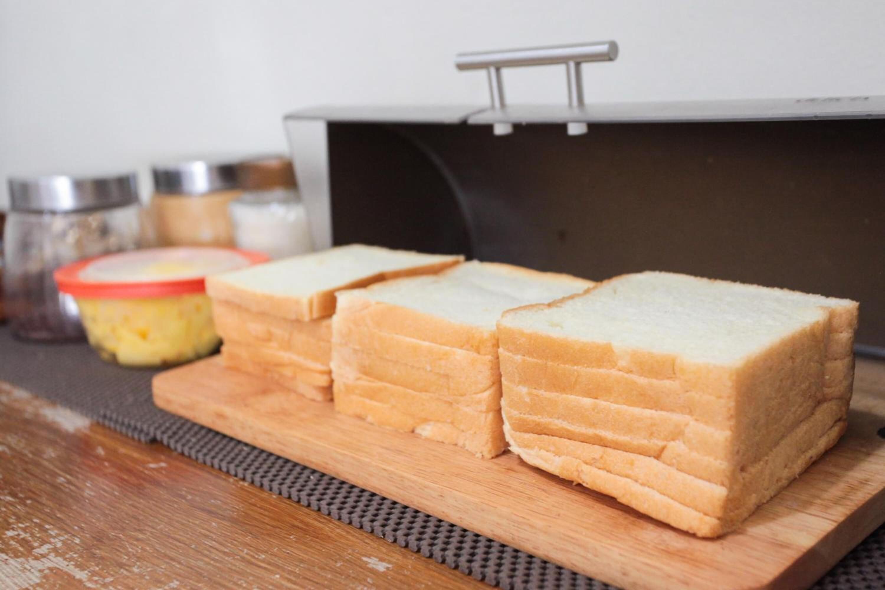 Slices of white bread on a wooden cutting board.