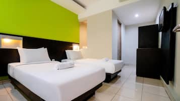 Una habitación de hotel con dos camas, televisión y un minibar.