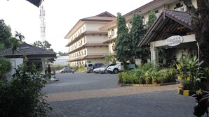 A hotel with a tiled roof, multiple floors, and a signboard. - Mega Matra Hotel (Jakarta)