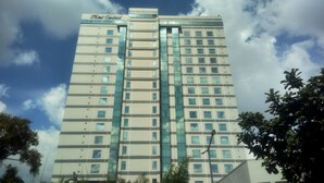 A high-rise hotel building with a modern design, featuring multiple floors and a prominent entrance. - Hotel Sentral Jakarta (Jakarta)