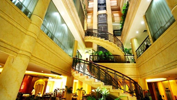 A grand hotel lobby with a central staircase, high ceilings, and decorative columns. - Hotel Sentral Jakarta (Jakarta)