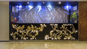 A reception area with a modern design, featuring a large illuminated wall with a floral pattern and a sign for 'phm hotels'. - 1O1 URBAN Jakarta Thamrin (Jakarta)