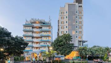 Um hotel com vários andares, de arquitetura tradicional, com varandas e uma entrada central.