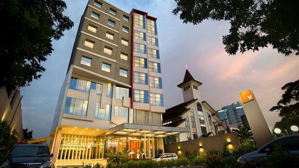 A multi-story hotel with a modern design, featuring a prominent entrance with a covered area and a visible tower structure. - V Hotel Tebet, Jakarta (Jakarta)