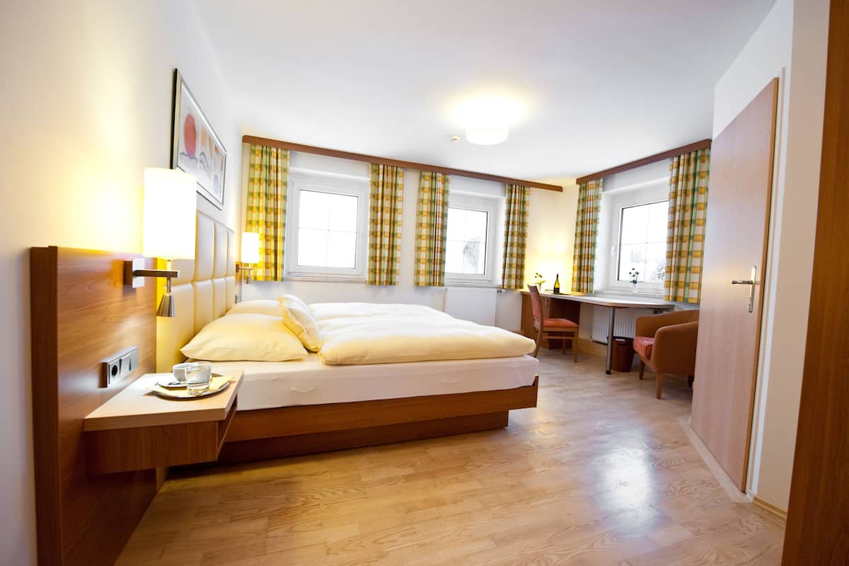 Une chambre moderne avec un grand lit, des tables de chevet, un bureau et une chaise.