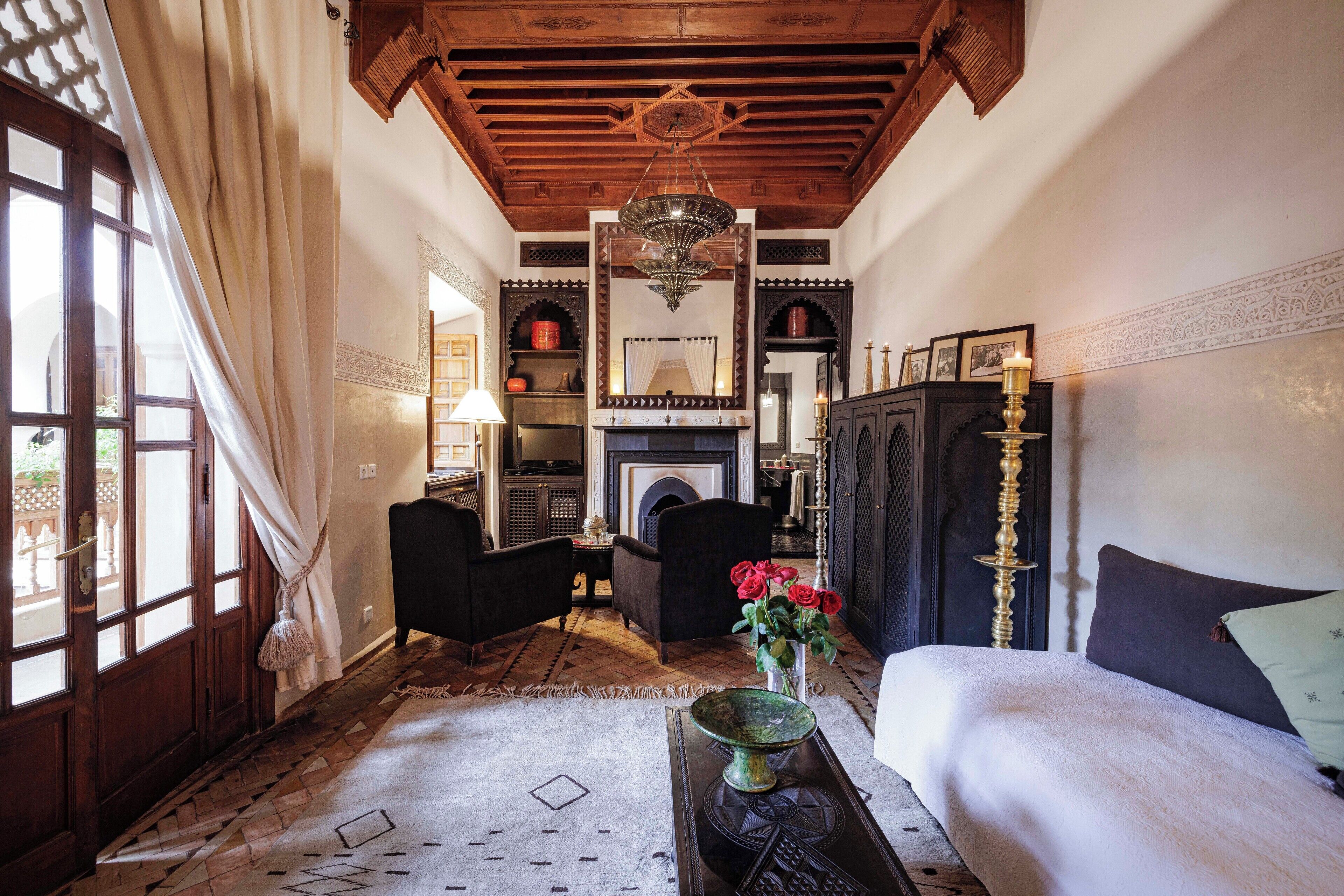 A traditional room with a fireplace, wooden furniture, and a chandelier.