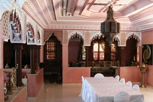 Una stanza con un tavolo grande, archi decorati e arredi tradizionali.