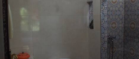 A bathroom with a toilet, sink, and shower.