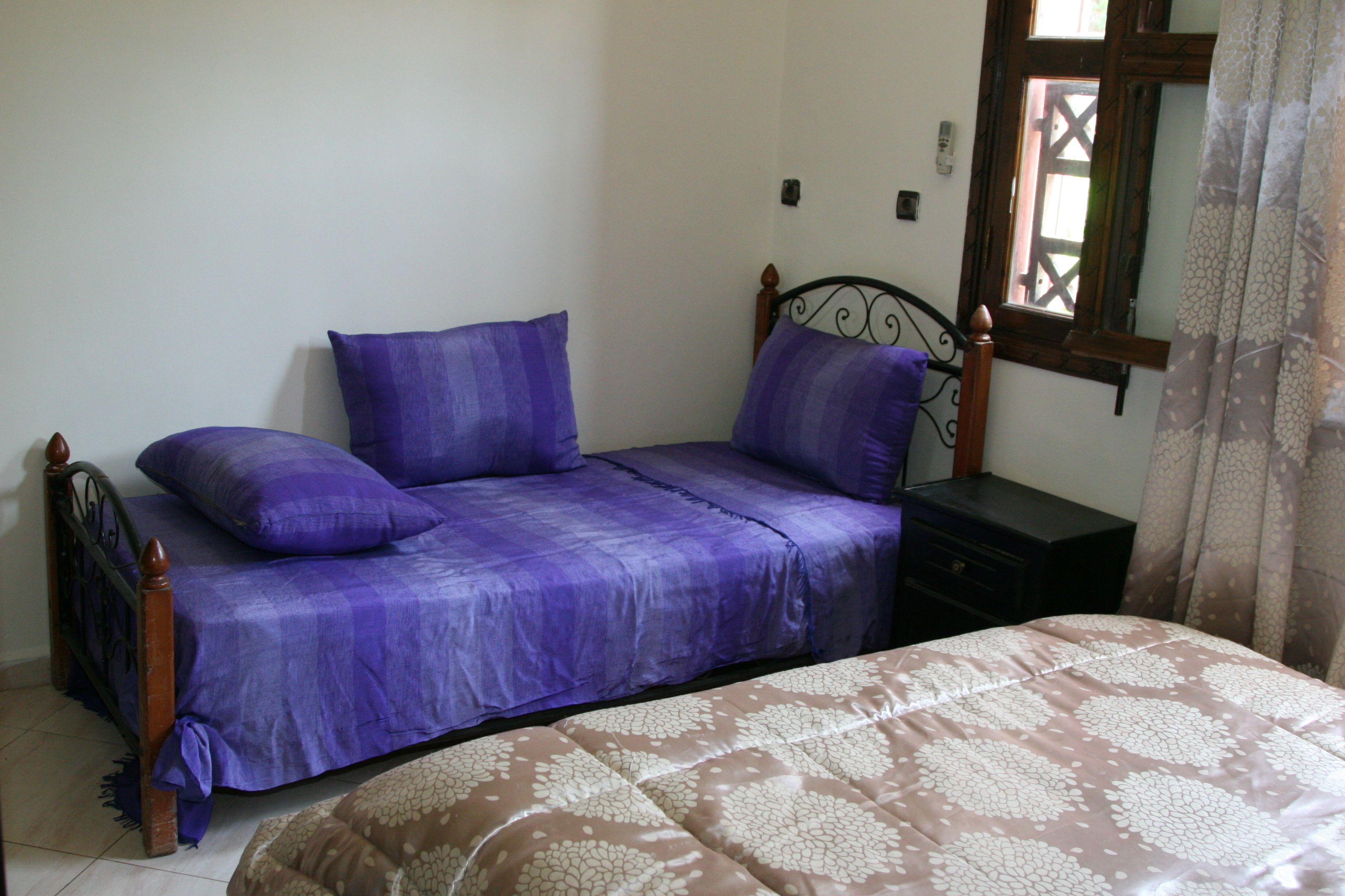 A bedroom with a bed, a nightstand, and a dresser.