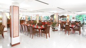 A spacious restaurant with multiple dining tables and chairs, large windows, and a modern interior design. - Le Dian Hotel (BANTEN)