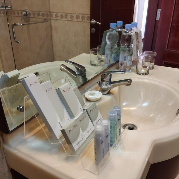Une salle de bain équipée d’un lavabo, d’un miroir et d’articles de toilette.
