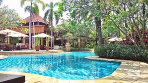 A swimming pool surrounded by lush greenery and outdoor seating areas. - Le Dian Hotel (BANTEN)
