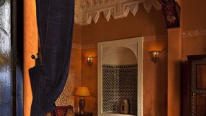 Una habitación con una cama, una silla, una mesa y una lámpara.