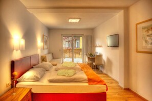 A hotel room with a bed, bedside table, lamp, and a television on the wall. - Hotel Fv Rst (Unterweissenbach)