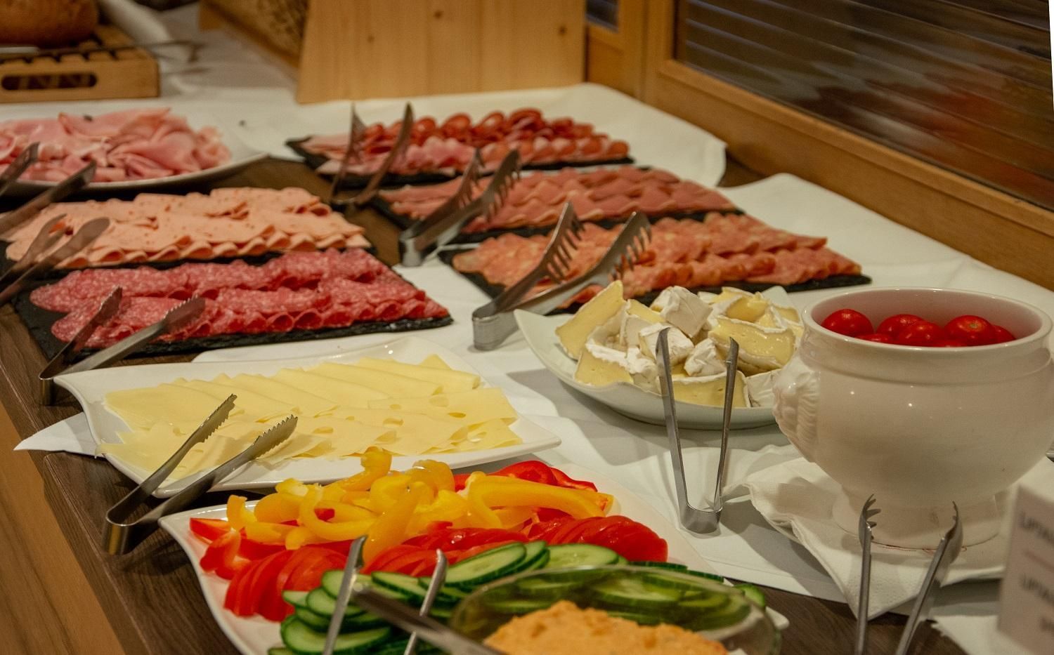 Ein Buffet mit einer Auswahl an Fleisch, Käse und Gemüse.
