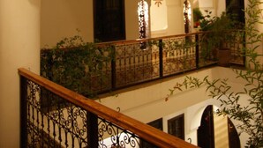A multi-level courtyard with arched walkways and a wooden railing. - Riad Ailen (Marrakech)
