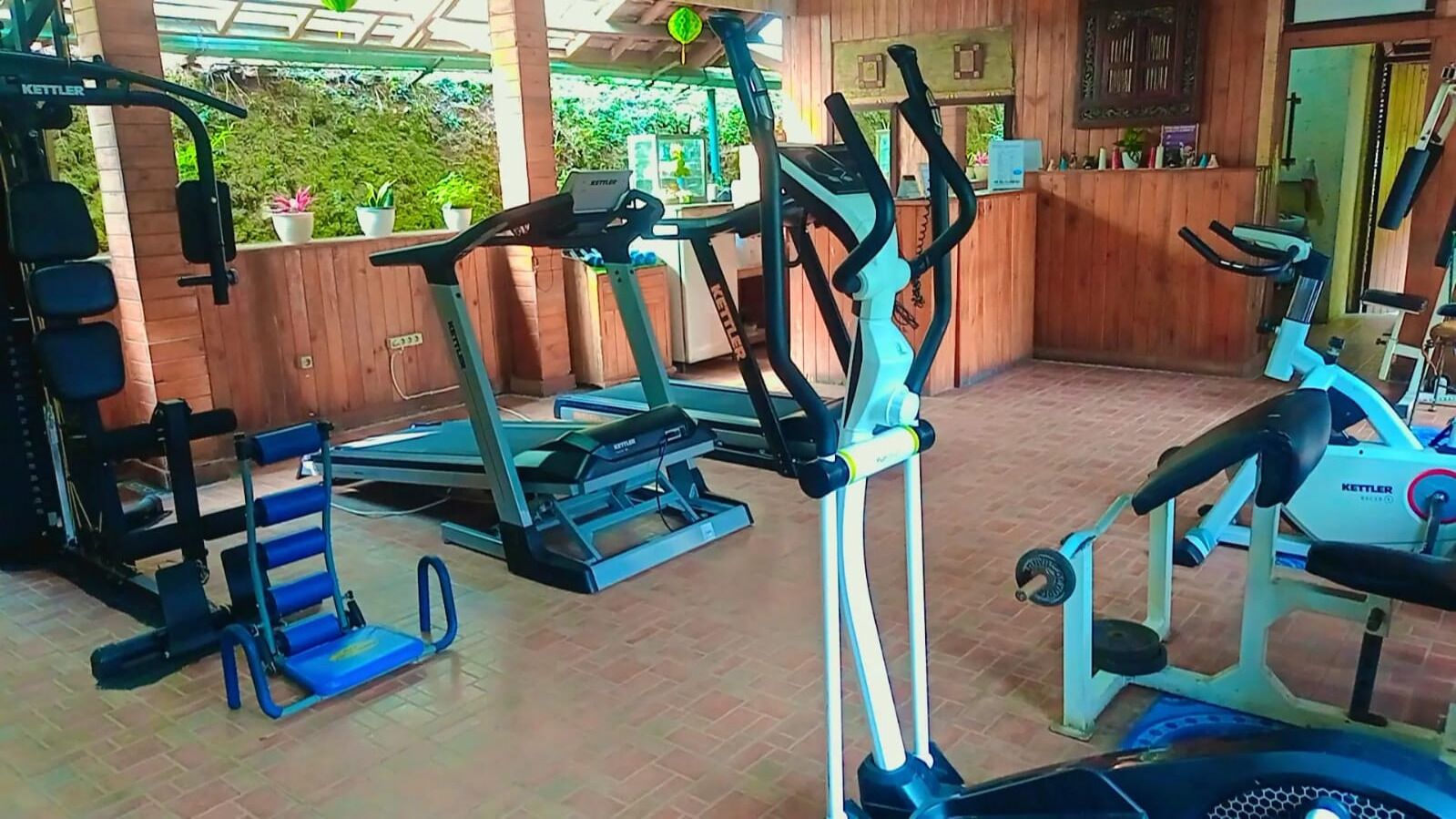 A gym with various exercise equipment including treadmills, a stair climber, and weight machines.
