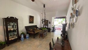 Uma sala de estar ampla com sofá, mesa de jantar e ventilador de teto.