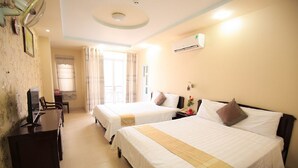 A hotel room with two beds, a desk, a TV, and an air conditioning unit. - Remi hotel (Nha Trang)