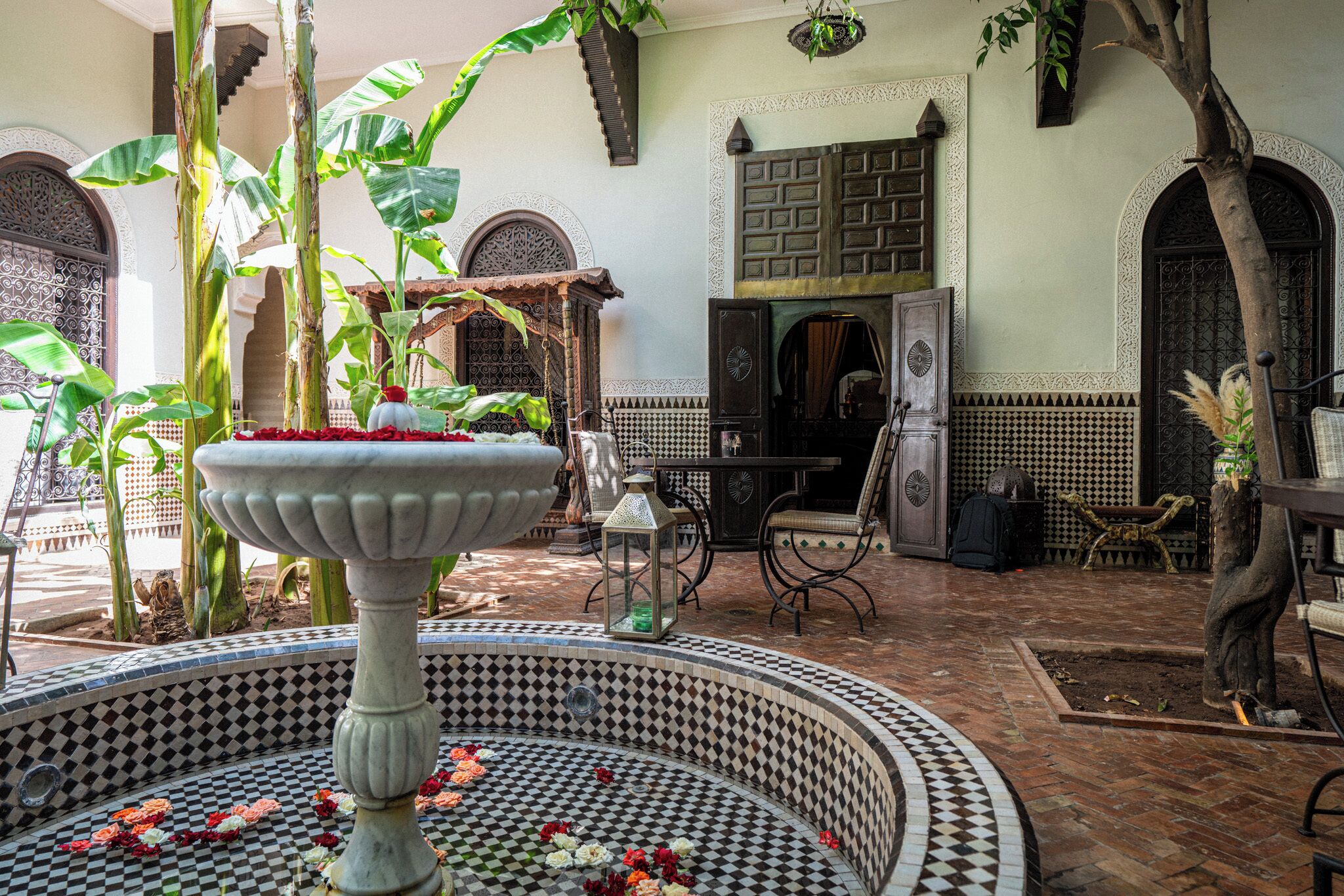 Un patio con una fuente, suelo de baldosas y elementos arquitectónicos tradicionales marroquíes.