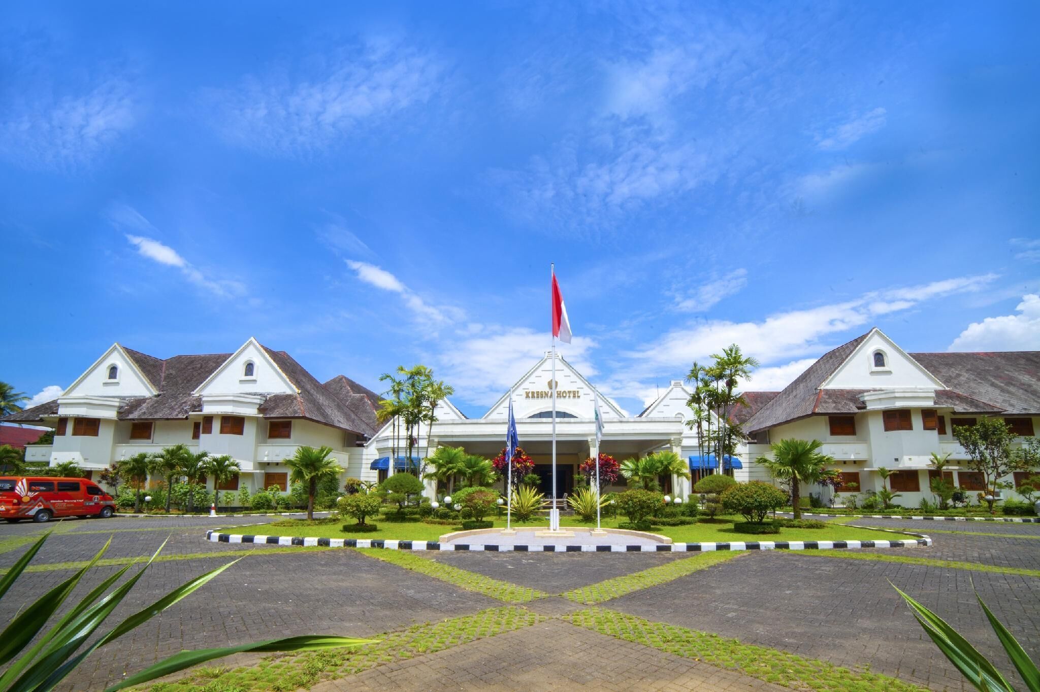 A hotel with a central entrance, multiple wings, and a flagpole.